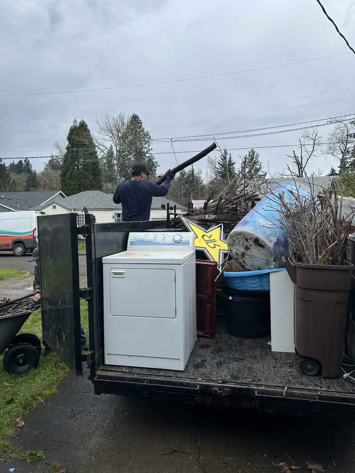 An EZ Junk and Hauling trailer loaded with appliances for recycling